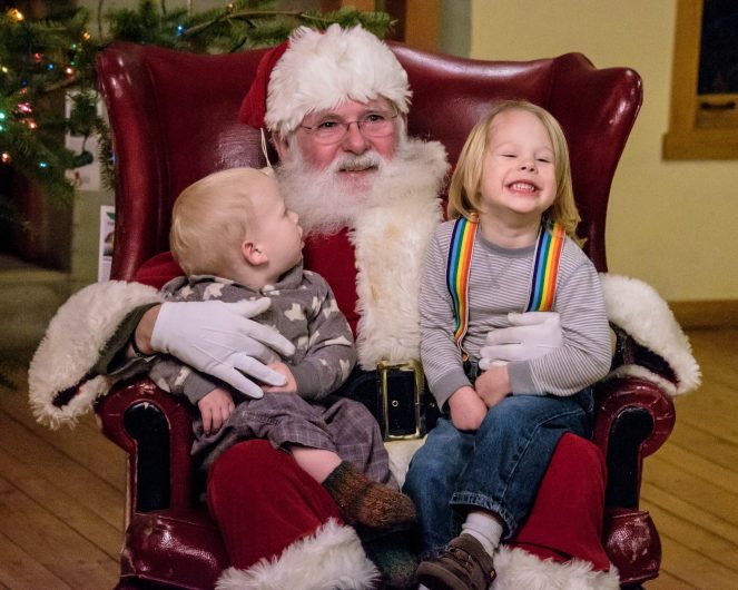 Enfants en train de se prendre en photo avec les père Noël