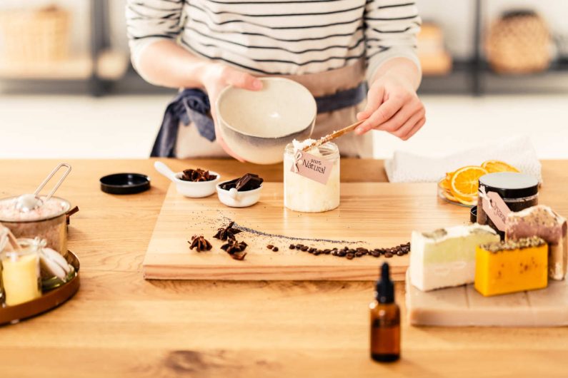 Close-up of a woman preparing organic face cream with coconut mass, cloves and oil